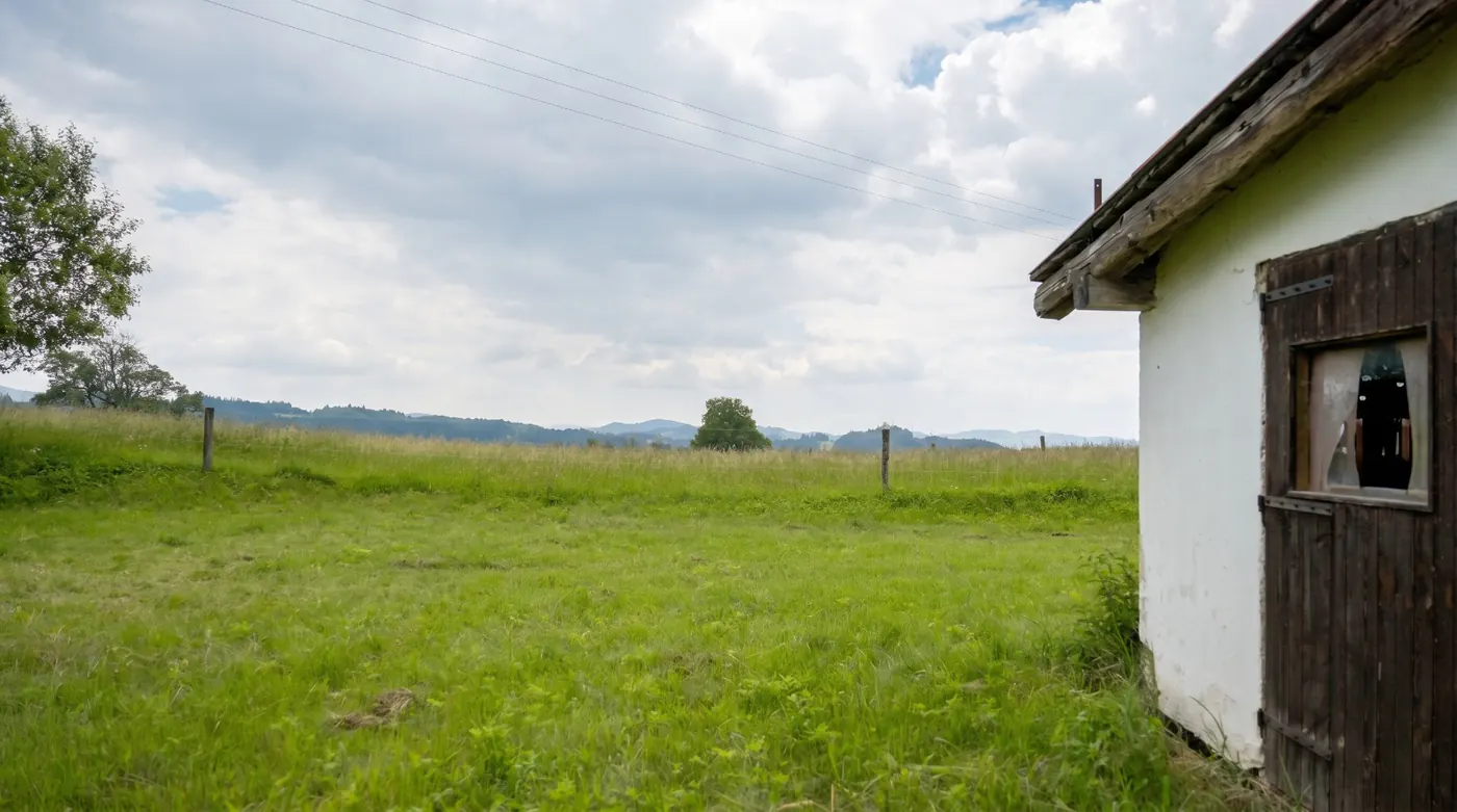 Pohled přes pozemek k hřebenům hor
